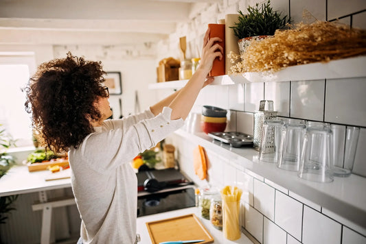 woman in kitchen reaching for cookbook